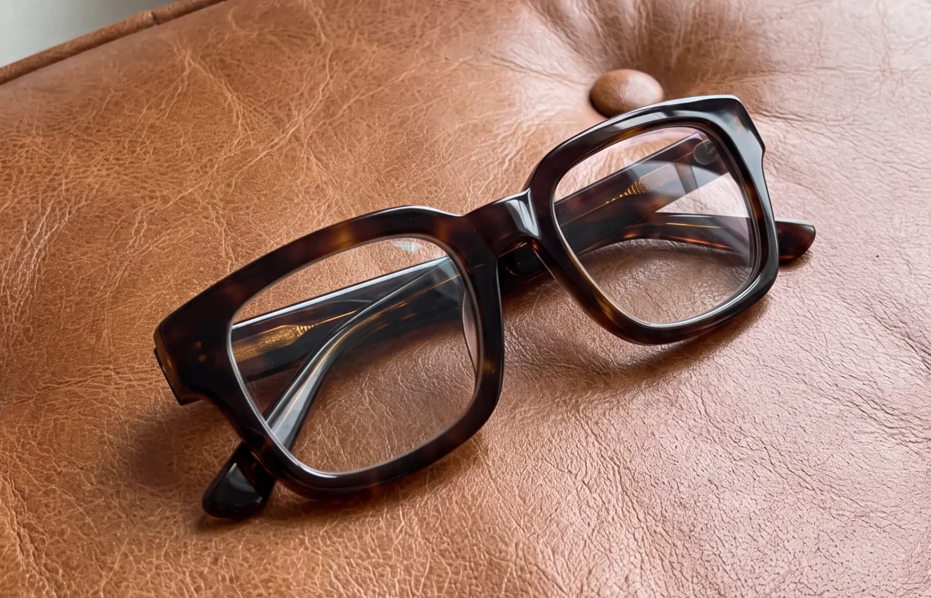 Sköldpaddsglasögon på läderstol — Frame Affair Archive second hand